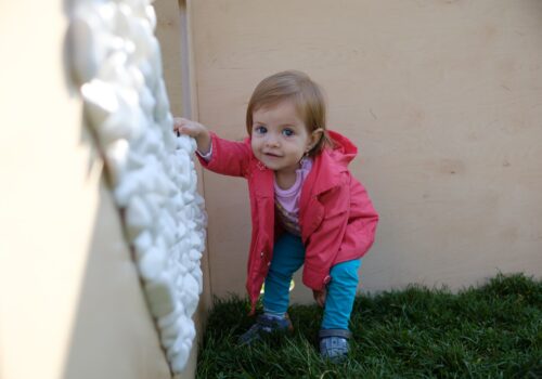 un copilaș atinge pietrele de panoul cu texturi al cazematelor