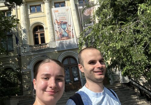 un beneficiar seeyou și ghidul în fața muzeului antipa. e soare și zâmbesc.