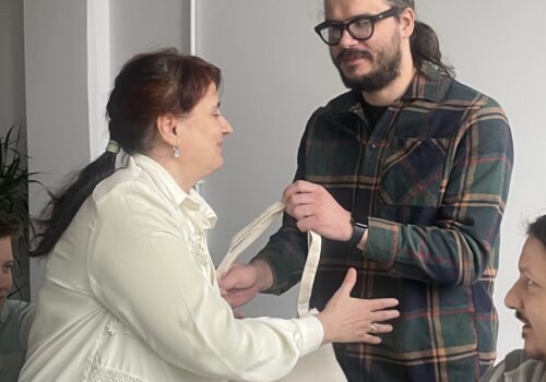 Alex Cucu, programator, îi înmânează Cristinei, absolventă, diploma și premiul